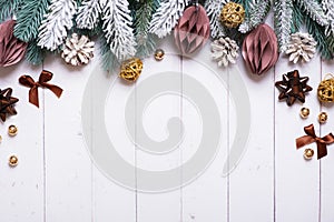Christmas holiday background with flat lay snow pine trees, paper Christmas toys on wooden background. Copy space.