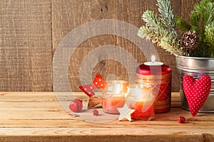 Christmas holiday background with pine tree branches, ornaments and candle decor on wooden table. Winter greeting card