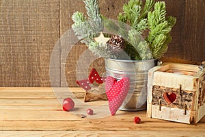 Christmas holiday background with pine tree branches, ornaments and candle decor on wooden table. Winter greeting card