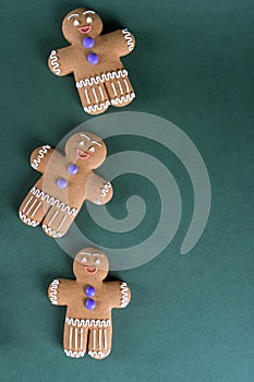 Christmas and holiday baking . Ginger men cookies with decor on green. Recipe green background.