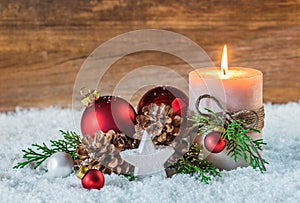 Christmas holiday celebration winter decoration with burning candle on snow and wooden background