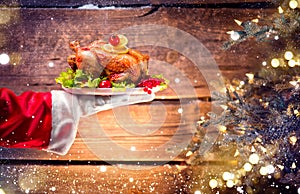 Christmas holiday dinner. Santa`s hand holding roasted chicken photo