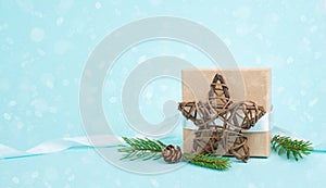 Christmas holiday greeting card with little gift box, pine cones and fir branches, blue background
