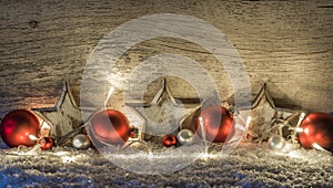 Christmas decoration with red balls, white stars lights over snow