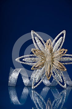 Christmas holiday snowflake and silver ribbon on dark blue background