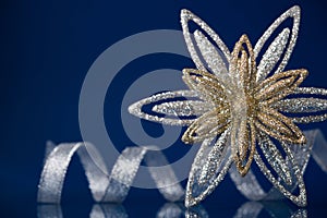 Christmas holiday snowflake and silver ribbon on dark blue background