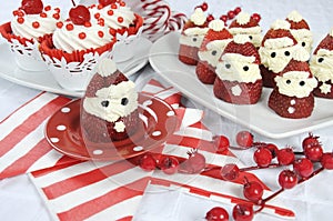 Christmas holiday Strawberry Santas with cherry red velvet cupcakes photo