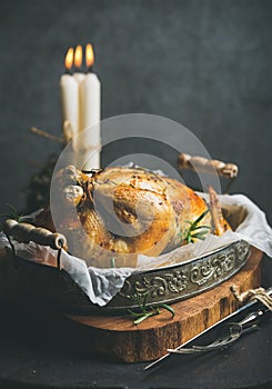 Christmas holiday table set with roasted whole chicken and candles