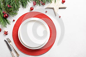 Christmas holiday table setting with white and red holiday decorations on white table