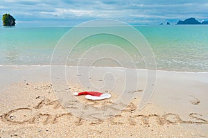 Christmas holiday tropical vacation concept, Merry Christmas written on tropical beach sand and sea background