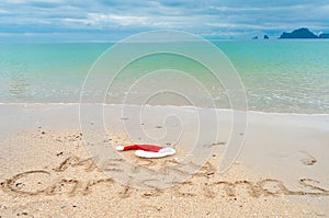 Christmas holiday tropical vacation concept, Merry Christmas written on tropical beach sand and sea background