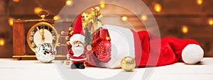 Christmas holidays banner with Santa Claus and hat with gifts.