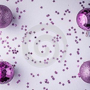 Christmas holidays composition, top view pink-purple-violet Christmas decorations on white-blue background with copy