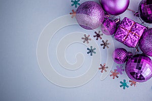 Christmas holidays composition, top view pink-purple-violet Christmas decorations on white-blue background with copy