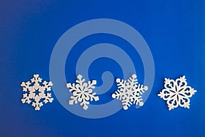 Christmas holidays composition, top view white snowflakes decoration on a blue-aquamarine background with copy space for