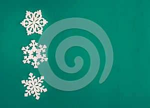 Christmas holidays composition, top view white snowflakes decoration on green and aquamarine background with copy space