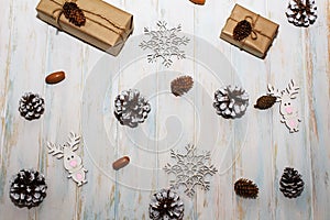 Christmas holidays composition on white wooden background. Craft boxes of gifts, pine cones