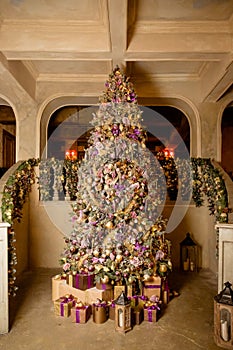 Christmas home interior with tree and stairs. Traditional living room in country house decorated with lights and candles