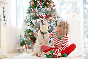 Christmas at home. Kids and dog under Xmas tree