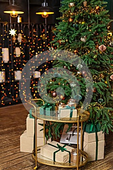 Christmas home room with fir tree and festive bokeh lighting, blurred holiday background, gift boxes and new year decor. Soft