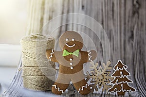 Christmas homemade gingerbread cookies with craft thread and wooden snowlake. Festive aesthetic card onwooden background