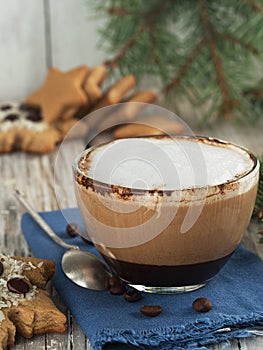 Christmas homemade gingerbread cookies, and a glass cup with hot cappuccino coffee. Close-up. Wooden vintage background, near the