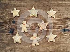 Christmas homemade gingerbread cookies of man and stars over rustic wooden background, top view.
