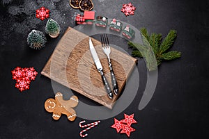 Christmas homemade gingerbread cookies, spices and cutting board on dark background