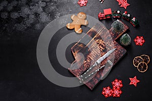 Christmas homemade gingerbread cookies, spices and cutting board on dark background