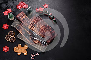 Christmas homemade gingerbread cookies, spices and cutting board on dark background