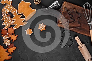 Christmas homemade gingerbread cookies, spices and cutting board on dark background with copy space for text top view