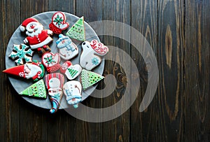 Christmas homemade gingerbread cookies, spices on the plate on dark wooden background among Christmas presents