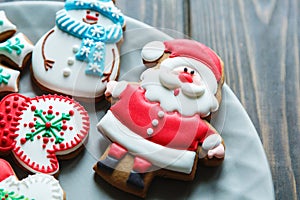 Christmas homemade gingerbread cookies, spices on the plate on dark wooden background among Christmas presents, top view.