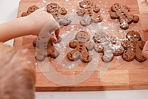 Christmas homemade gingerbread man cookies. Gingerbread Girls and Boys Dough on Wooden Background. Children& x27;s hand and