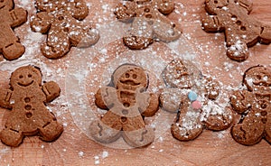 Christmas homemade gingerbread man cookies. Gingerbread Girls and Boys Dough on Wooden Background. Children& x27;s hand and