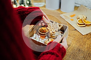 Christmas Homemade Sweet Hampers in female hands. Woman hsnds holding Christmas Sweet Gift Box. Festive treats Gift