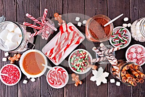 Christmas hot chocolate bar with a mixture of sweet toppings over dark wood