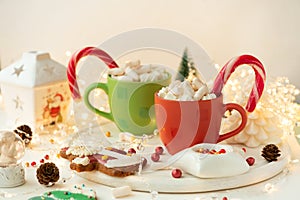 Christmas hot chocolate with marshmallow and gingerbread cookies on white wooden table. Traditional hot drink at Christmas