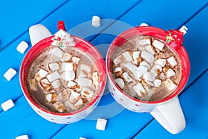 Christmas hot chocolate with marshmellow on blue wooden background