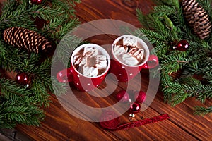 Christmas hot chocolate with marshmelow on a dark wooden background, christmas tree branches decorating.