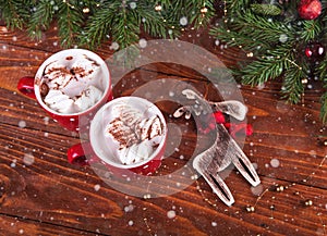 Christmas hot chocolate with marshmelow on a dark wooden background, christmas tree branches decorating.