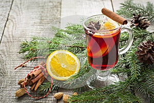 Christmas hot mulled wine with cinnamon, orange and christmas tree on wooden board. Winter tradition drink.