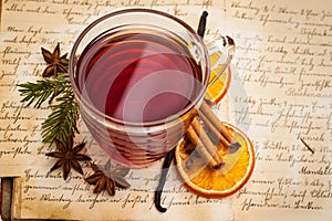 Christmas: Hot spiced wine with spices on an old cookbook from above