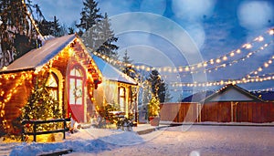 A Christmas house beautifully lit up at night amidst the snow covering the house and road