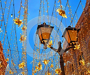 Christmas illumination decoration in Moscow on Nikolskaya street. Yellow stars, garlands. Holiday New Year in the city