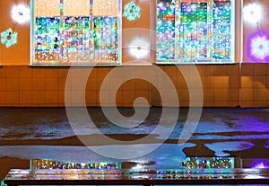 Christmas illumination, wet bench and rain puddle