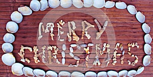 Christmas inscription from white corals and shells on wooden background.