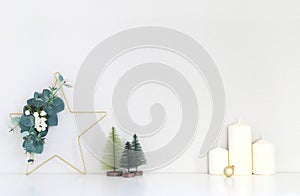 Christmas interior, candles, decorative Christmas trees, Christmas wreath in the shape of a star decorated with eucalyptus branch