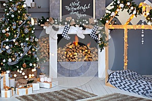 Christmas interior of living room with decorated Christmas tree,  fireplace with Christmas socks and wooden bed in shape of house.