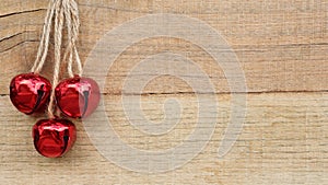 Christmas jingle bells laying on a natural wood background with copy space
